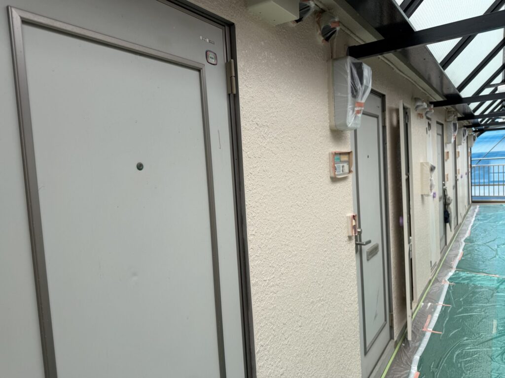 市川市アパート共用部でパイプスペース扉のペーパー掛け前後を確認している様子